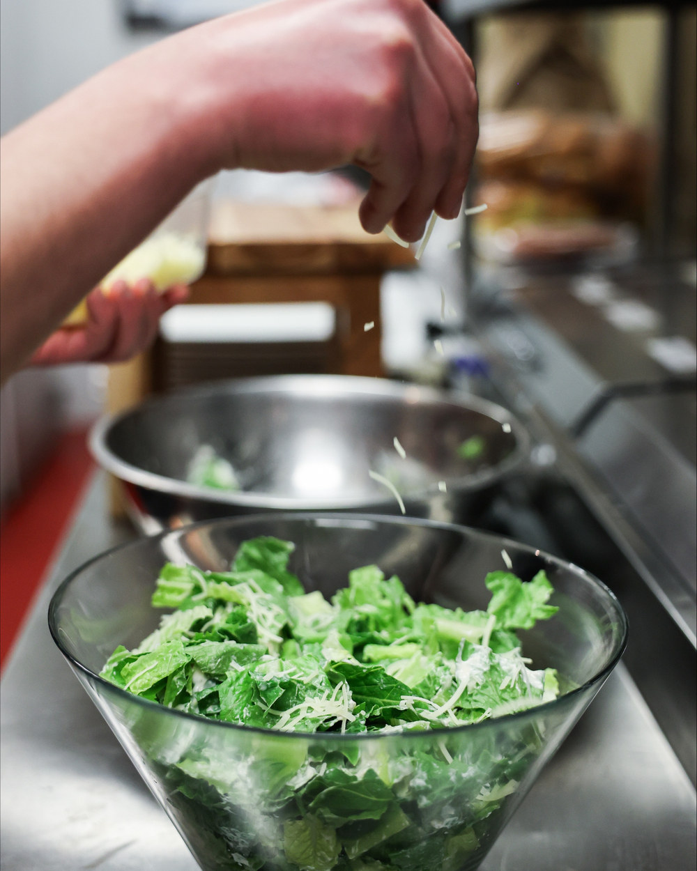 Caesar salad being tossed fresh in the kitchen