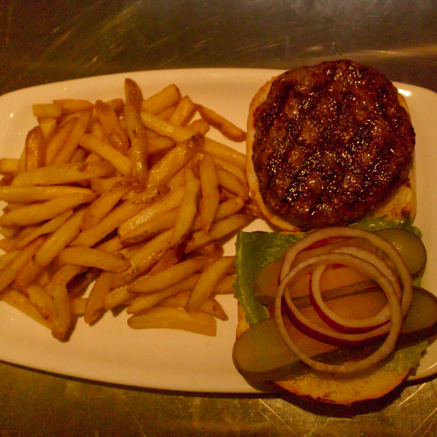 A grilled burger with fries
