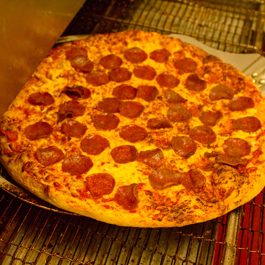 A 16-inch pepperoni pizza coming out of the oven